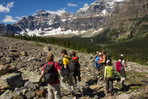 Hiking group in the scree field, Rocky Mountains, snowy mountains in the background, Canada Hiking group in the scree field, Rocky Mountains, snowy mountains in the background, Canada